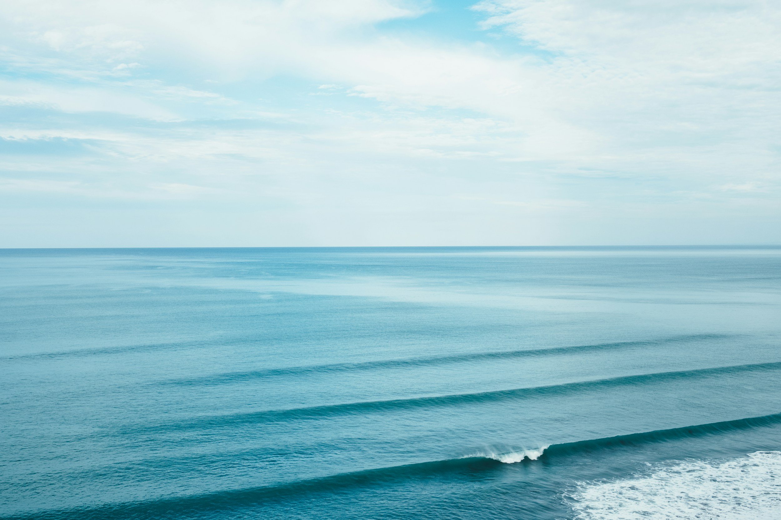 Calm open sea meeting a pale horizon